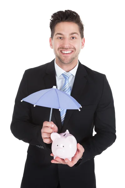 Businessman Sheltering Piggybank — Stock Photo, Image