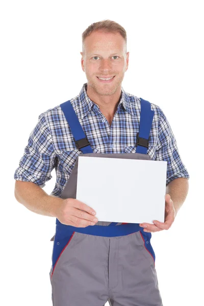 Handyman sosteniendo la placa en blanco — Foto de Stock