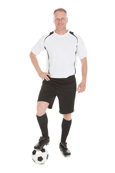 Jogador com perna na bola de futebol — Fotografia de Stock