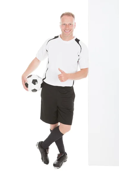 Jugador de fútbol señalando en la cartelera — Foto de Stock