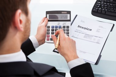 Businessman Calculating Invoice