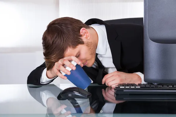 Hombre de negocios cansado sosteniendo la taza de café — Foto de Stock