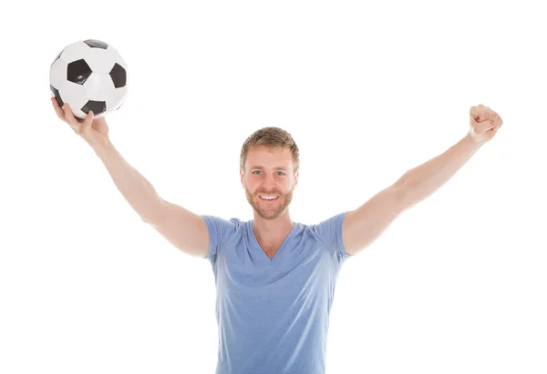 Uomo con le braccia sollevato tenendo palla da calcio — Foto Stock