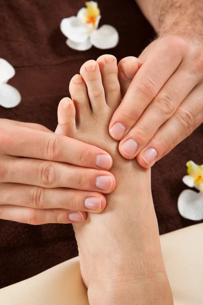 Therapist Giving Foot Massage Stock Photo