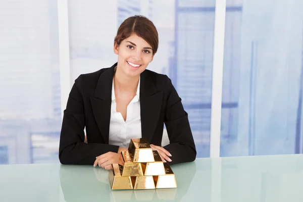 Geschäftsfrau zeigt Goldklötze — Stockfoto