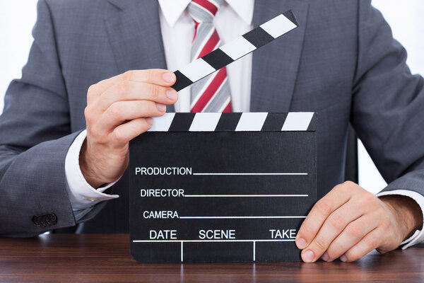 Businessman Holding Clapper Board