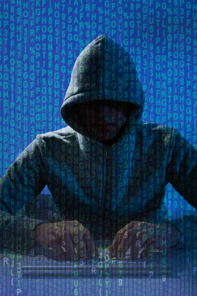 Mannen i balaclava hacking laptop — Stockfoto