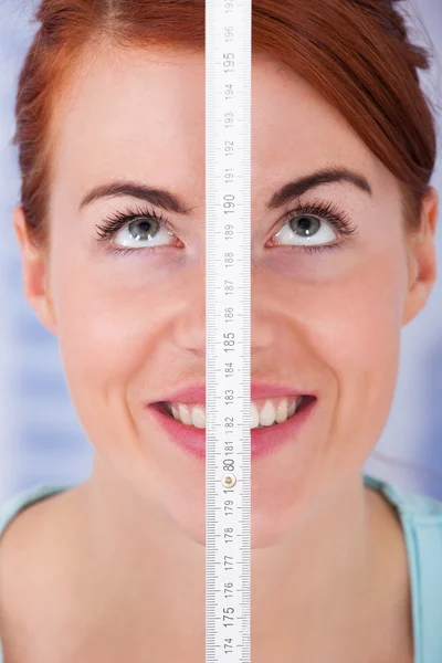 Kvinna mätning av höjd med åtgärd tejp — Stockfoto