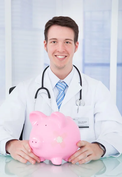 Docteur examinant la tirelire avec stéthoscope — Photo