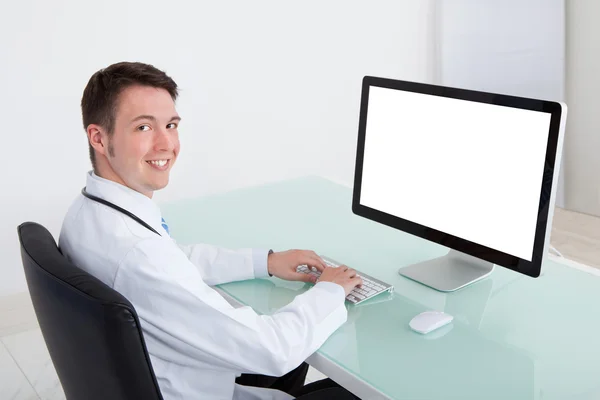 Bilgisayarda çalışarak kendine güvenen erkek doktor — Stok fotoğraf