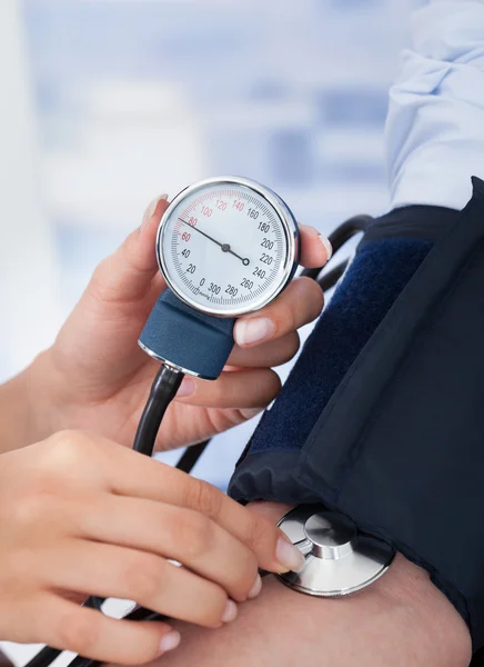 Médico verificando a pressão arterial — Fotografia de Stock