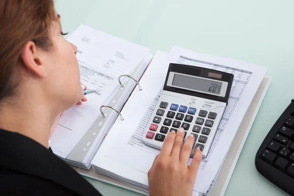 Affärskvinna beräkning av räkningar på skrivbord — Stockfoto