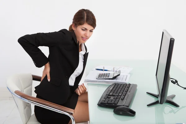 Mujer de negocios que sufre de dolor de espalda — Foto de Stock