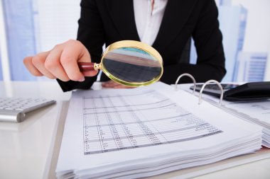 Büyüteç ile faturaları scrutinizing işkadını
