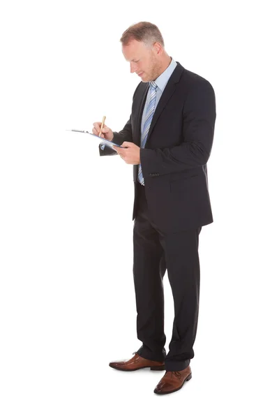 Businessman Writing On Clipboard — Stock Photo, Image