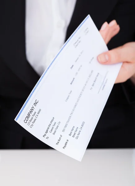 Zakenvrouw bedrijf cheque — Stockfoto