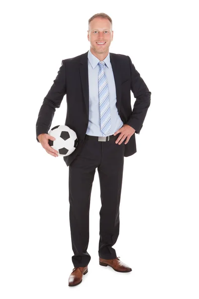 Homme d'affaires tenant un ballon de football — Photo