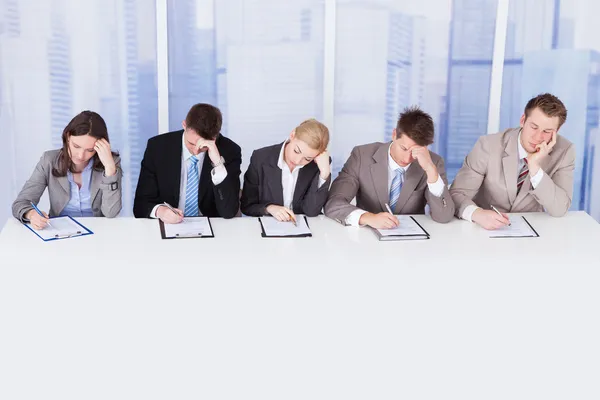 Ermüdetes Firmenpersonal am Tisch — Stockfoto