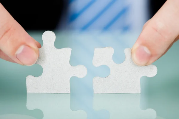 Businessman Joining Puzzle Pieces — Stock Photo, Image