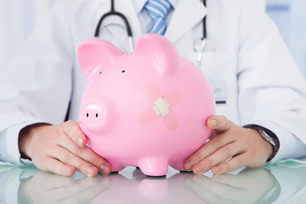 Doctor Holding Piggybank — Stock Photo, Image