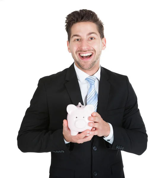 Homem de negócios segurando piggybank — Fotografia de Stock