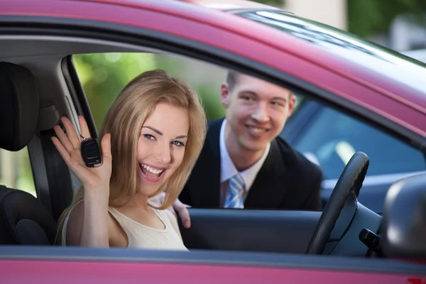 Frau zeigt Schlüssel im Auto — Stockfoto