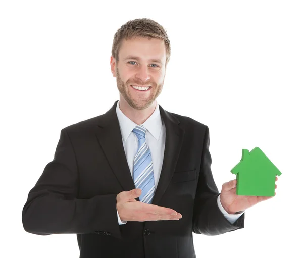 Empresário mostrando modelo de casa — Fotografia de Stock