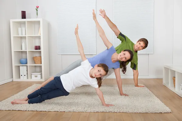 Apto família fazendo Yoga — Fotografia de Stock