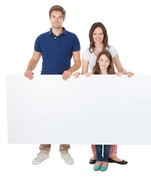 Familia sosteniendo cartelera en blanco — Foto de Stock