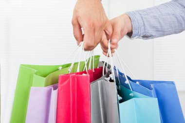 alışveriş torbaları tutan eller