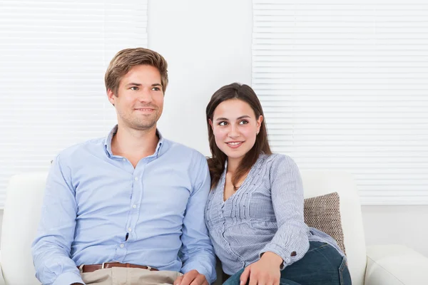 Pareja sentada en sofá — Foto de Stock