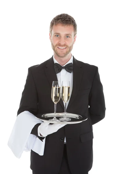 Waiter carrying champagne flutes on tray — Stock Photo, Image