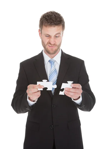 Businessman holding puzzle pieces — Stock Photo, Image