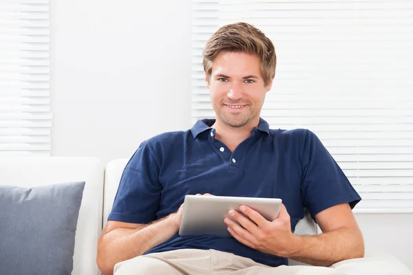 Homem sorridente usando tablet digital — Fotografia de Stock