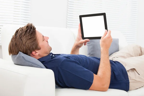 Man met digitale Tablet PC op sofa — Stockfoto