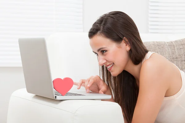 Молодая женщина знакомится онлайн на ноутбуке — стоковое фото