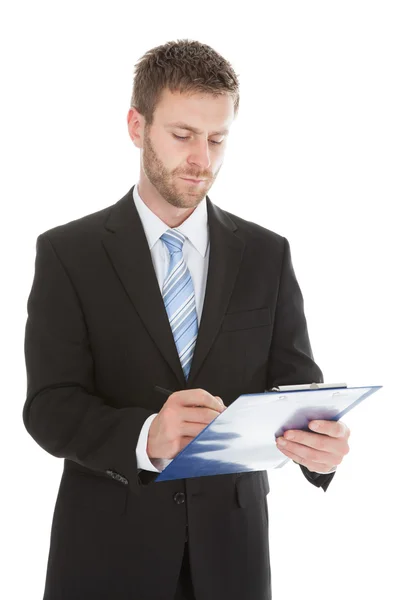 Businessman writing notes on clipboard Royalty Free Stock Images