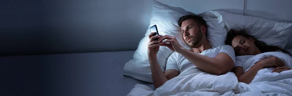 Man Fuskar Mobiltelefon Otrohet Sängen — Stockfoto