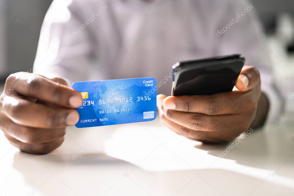 Person With Credit Card And Mobile Phone Doing Online Banking