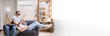 Klima kullanan mutlu aile çifti. AC apartmanı.