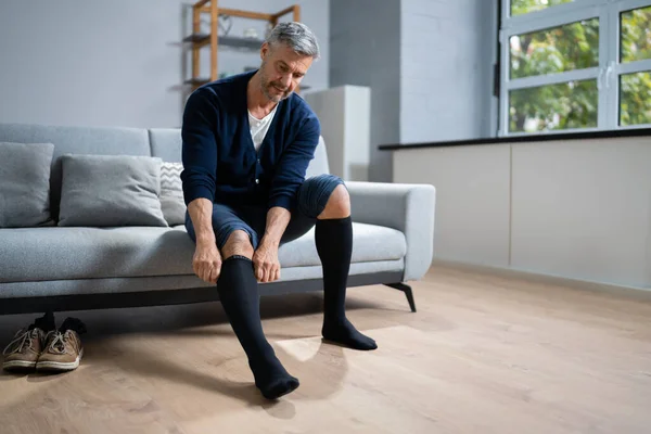 Man Putting Medical Compression Stockings Legs — Stock Photo, Image