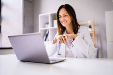 Doktor iş arkadaşlarıyla dizüstü bilgisayarda video konferansı yapıyor.