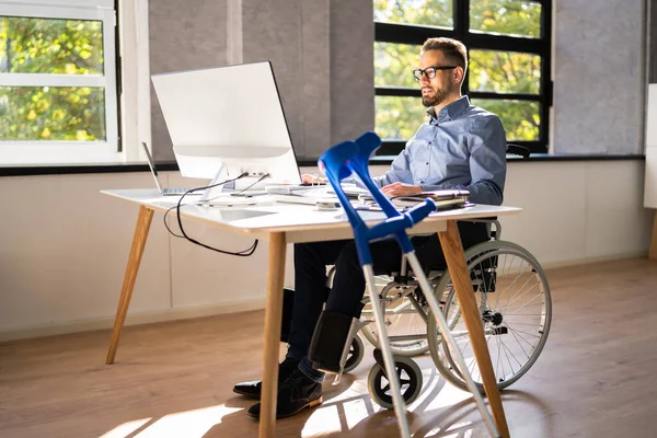 コンピューターを使って仕事をしている障害のあるビジネスマン — ストック写真