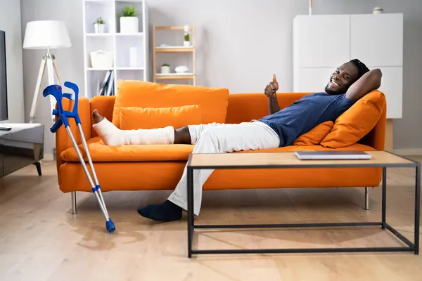 Gebrochenes Bein Bei Der Genesung Mann Mit Verletzungen Auf Sofa — Stockfoto
