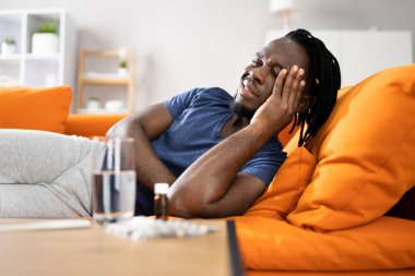 Baş ağrısı ve stresi olan yorgun Afrikalı Amerikalı adam.