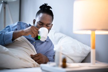 Hasta Afrikalı Amerikalı Adam Yatakta İçiyor