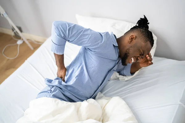 Άνθρωπος Που Υποφέρει Από Πόνο Στην Πλάτη Κάθεται Στο Κρεβάτι — Φωτογραφία Αρχείου