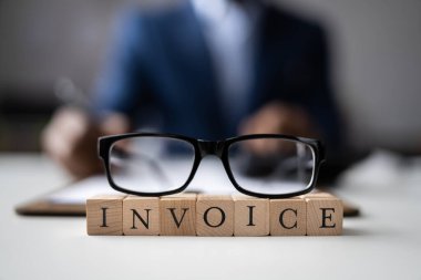 Ahşap masa başında hesap makinesini kullanarak Fatura hesaplama işadamı