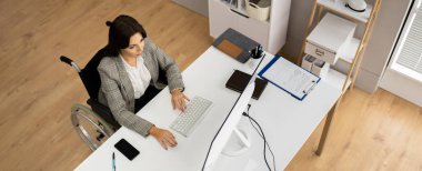 Dizüstü bilgisayar kullanan Tekerlekli Sandalyedeki İşçi