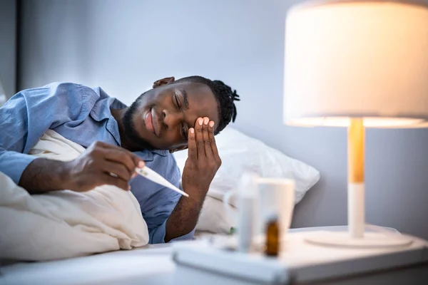 Homem Doente Com Febre Usando Termômetro Cama — Fotografia de Stock